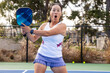 © Mat Hayward - Female pickleball player having fun during a game on an outdoor court. She has a wild expression of shock and surprise.