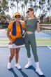 © Mat Hayward - Two women standing together on a pickleball court outside.