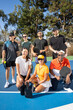 © Mat Hayward - Group of seven friends together on pickleball court. The diverse players are laughing and smiling together outside and having fun. Multi-ethnic people and diversity in age and gender.