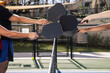 © Mat Hayward - Four pickleball players tapping racquets over the net after a fun game in the sun outside.