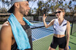 © Mat Hayward - A young man talking with a woman on a pickleball court after a competitive game. The conversation is lively outside.