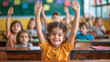 Children in elementary school are raised hand in clasroom.