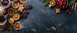 Christmas baking ingredients including gingerbread, fruitcake, and seasonal beverages on a black stone surface with cranberries, dried oranges, cinnamon, and spices. Top view with space for text.