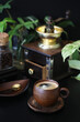 Wooden coffee cup and old vintage coffee grinder in dark settings
