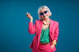 Fototapeta Młodzieżowe - Fashionable Senior Lady Posing in Trendy Sunglasses and Pink Blazer