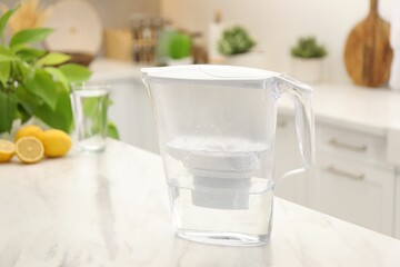 Wall Mural - Water filter jug, glass and lemons on white marble table in kitchen