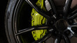 Close up of a black alloy wheel with a green brake caliper