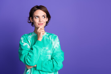 Poster - Photo portrait of attractive young woman touch chin look empty space dressed stylish green clothes isolated on violet color background