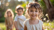 © Sudarshana - A group of small children in blurred background and one cute little girl smiling and looking at the camera