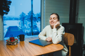 Wall Mural - Smiling happy woman working on laptop while sitting at table. Young creative woman working and typing on keyboard at home. Work at home concept