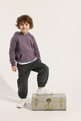 Fashion concept. Stylish boy with vintage suitcase on white background