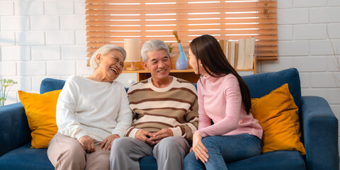 Asian Family Bonds: Daughter's Laughter Echoes in the Home as Grandfather and Grandmother Enjoy Retirement, Sharing Hugs and Smiles on the Sofa, A Precious Elderly Bonding Moment