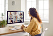 © Studio Romantic - Corporate business team having a remote meeting. Young woman in casual clothes sitting at her desk at home, attending an online conference, looking at the computer screen, and smiling