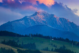 Fototapeta Perspektywa 3d - mountain sunset in the spring with Ceahlau peak in snow and green meadow on countryside of Romania Carpathians.
