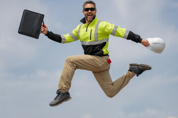 Wall Mural - Fast building. Funny construction worker jumping. Excited jump of builders run in helmet. Worker in hardhat. Construction engineer in builder uniform run and jump. Excited foreman.