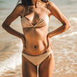A woman wearing a bikini on the beach, showing off her flat stomach, good physical health and natural girl's body 