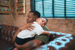 © chokniti - Smiling African-American father shares fun and love with his cheerful children at home, celebrating family with childhood together, African American black person in happy together of father's day