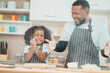 © chokniti - In a home kitchen, black father and his daughter bond over cooking a meal food, their laughter and love filling the air, embodying the joy of African American family life, Father's Day concept