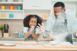 © chokniti - In a home kitchen, black father and his daughter bond over cooking a meal food, their laughter and love filling the air, embodying the joy of African American family life, Father's Day concept