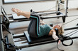 © Mauro Grigollo/Stocksy - Woman doing pilates exercises in a gym