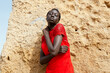 © Hind Bouqartacha/Stocksy - portrait of a young woman of color in a flowing red dress at the beach