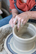 Potter's hands throwing a bowl on a pottery wheel