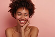 © Maksym - Against a neutral background, a 40-year-old woman removes makeup with finesse, displaying her glowing skin and joyful smile in a scene reminiscent of a cosmetics ad.