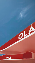 Bright Red Umbrellas Against A Blue Sky With Olá Lettering