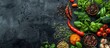 Spices, herbs, and fresh vegetables arranged on a dark metal background with room for text. Viewed from above. Ingredients for healthy and organic cooking.