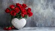 Red roses in a heart shaped vase, plain gray background   