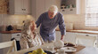© peopleimages.com - Elderly, married couple and smile in kitchen for breakfast, morning or relax for retirement, love or support. Pensioners, talking and home for cake for relationship, joy and trust for happiness
