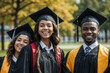 European and Afro young graduates in elegant black gowns and caps smiling joyfully. They stand closely grouped in a scenic park, with soft focus trees in the background on a sunny day