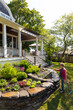 © Raymond Forbes LLC/Stocksy - Senior Citizen Gardener in backyard of Home Watering garden Lifestyle