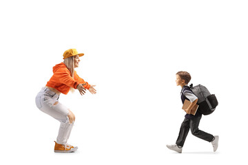 Canvas Print - Full length profile shot of a schoolboy running to hug a young female