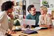 © ALTO IMAGES/Stocksy - Smiling financial advisor discussing insurance policy with couple
