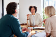 © ALTO IMAGES/Stocksy - Smiling financial advisor discussing sales performance with couple