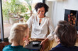 © ALTO IMAGES/Stocksy - Happy insurance agent talking with clients at home