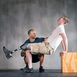 © peopleimages.com - Trainer, person with a disability and prosthetic leg and training in physiotherapy, studio and gym block. Male people, physiotherapist and amputee for wellness, fitness and exercise in rehab center