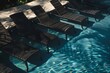 Five chaise lounge chairs by the pool .