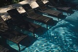 Fototapeta  - Five chaise lounge chairs by the pool .