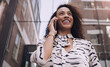 Woman, city and smile with smartphone, call and vision for communication on urban background. African entrepreneur, conversation and technology for business, working and downtown corporate startup
