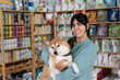 © nomad studio/Stocksy - Woman with dog at pet store.