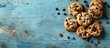 Chocolate chip cookies displayed on a weathered blue table. Traditional American food. Space for text. Large horizontal advertisement.