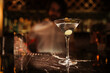Elegant Martini on Marble Bar with Blurred Bartender