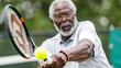 A dressed for sports individual Mature man with glasses is playing tennis, captured mid-stroke while contacting the ball with the tennis racket.