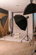 © Ezequiel Giménez/Stocksy - Modern photographic studio with umbrella flash lights and stool