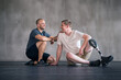© peopleimages.com - Physiotherapist, man with a disability and prosthetic leg and laughing in physiotherapy, studio and sportswear. Male people, trainer and amputee fitness for wellness or exercise in sports center