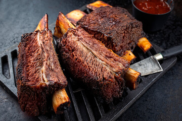 Wall Mural - Traditional barbecue burnt chuck beef ribs marinated with spicy rub and served as close-up on a rustic cast iron grillage