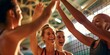 © keiron - Four diverse women high five indoor volleyball game candid moment, support and team spirit