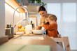 © Santi Nuñez/Stocksy - Mother and son baking together at home